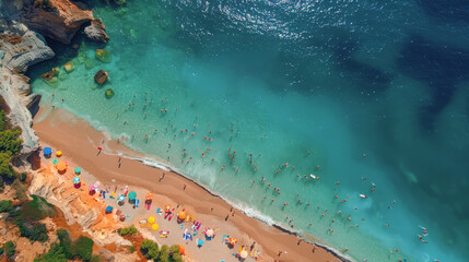 Aerial view of a vibrant beach scene with colorful umbrellas, sunbathers, and swimmers in turquoise waters on a sunny day.
