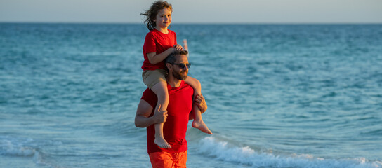Fathers day. Father walking with a little child son on beach near sea. Dad with son walking on a...