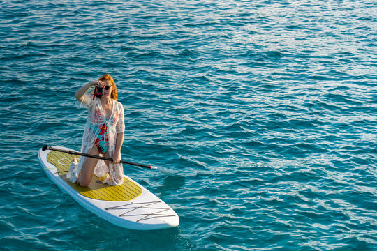 Woman Taking Photo from Stand Up Paddle Board on Caribbean Vacat