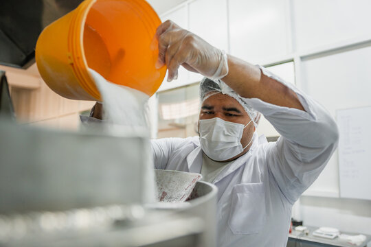 Adding sugar in a industrial kitchen pot