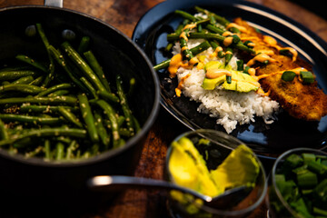 several dishes with rice, beans and green beans are laid out on a table