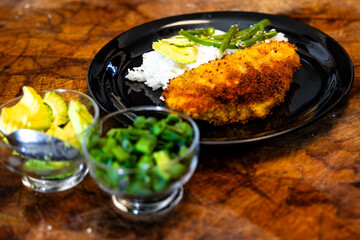 a plate with some chicken cutlets and rice and fruit