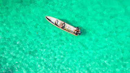 Single boat drifting near the shore of Bateria beach, Sao Tome, South Africa