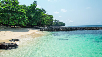 Beach on a sunny day with water and plants nearby, Ilheu das Rolas islet in Sao Tome, Africa