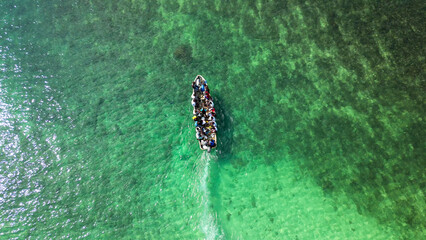 People in a boat sailing on turquoise sea in Sao Tome and Principe, Africa