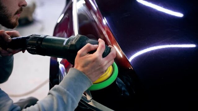 close-up of the hands of a car mechanic at a service station doing the final polishing to shine