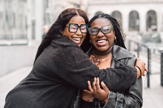 Two friendly women laughing together on the street