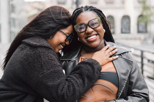 Two friendly women laughing together on the street