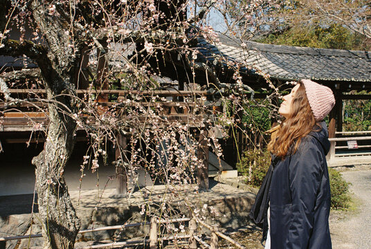 Young woman smells flowers from a tree