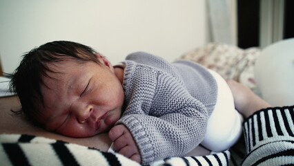 Sleeping newborn baby resting on mother's chest during initial stage of life, first days of a human...