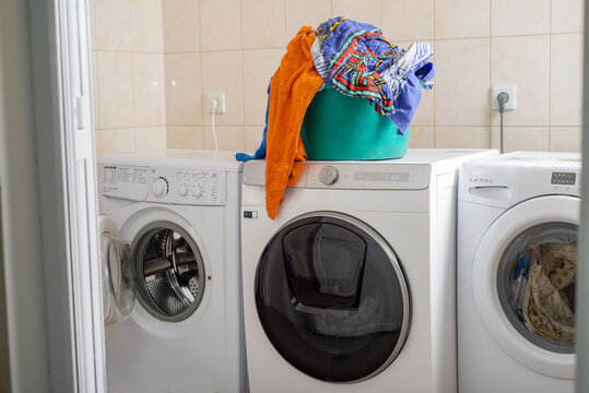 Basket of washed clothes on a washing machine in a laundry room