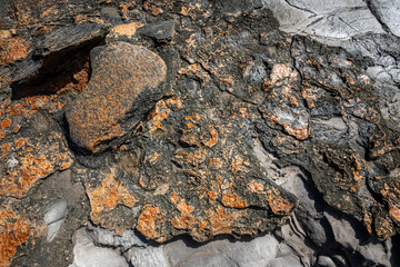 Closeup of orange and black lava rock at Makalua-Puna Point, Maui, Hawaii, as a textured nature background
