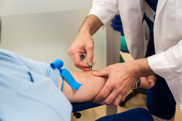 Healthcare professional drawing blood from patient