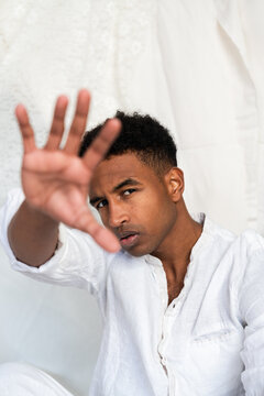 Man in white shirt gesturing stop with hand