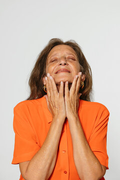 Elderly woman in orange shirt in studio