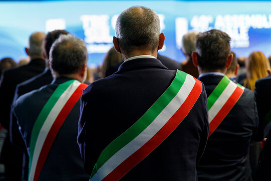 Uomini di spalle con la fascia tricolore italiana sulla giacca