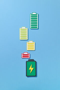 Handmade paper icon of charging battery with colorful cells