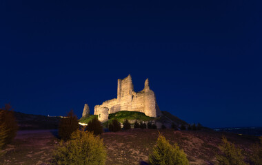 Castle de Santiago or Torre de los Piquillos illuminated at night under a starry sky.