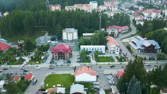 Aerial view of cars driving on Bulevardul Libertatii in front of Busteni Town Hall, Prahova, Romania