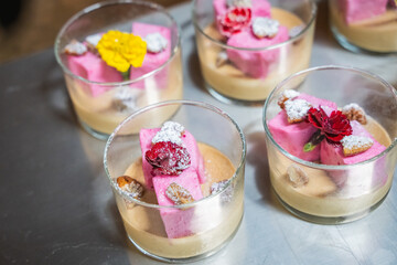 several desserts in cups with colorful fruit toppings displayed