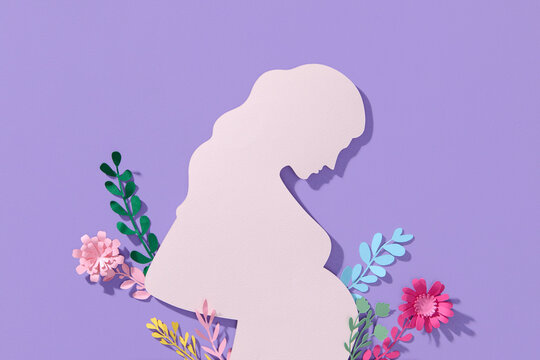 Silhouette of a young pregnant woman on a puple background