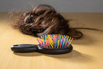a woman's hair sits next to a brush with colored hair