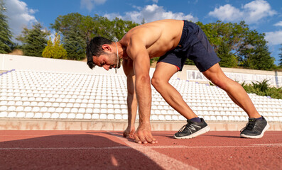 Stadium, man running and start block of athlete on a runner and arena track for sprint