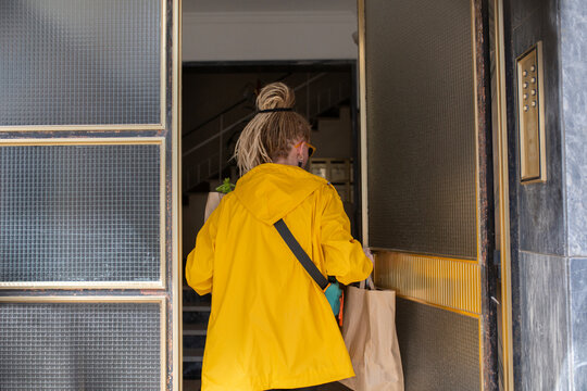 Pretty woman in yellow raincoat wearing sunglasses with dread hairstyl