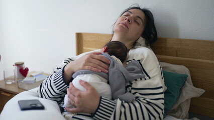 Tired mother sleeping with newborn baby on chest during first days of his life, exhausted mom...