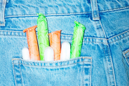 Denim jeans and period/menstrual products tampons in pocket with flash