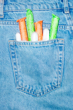 Denim jeans and period/menstrual products tampons in pocket with flash