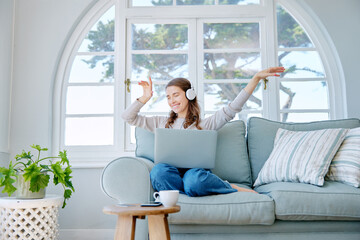 Woman, laptop and headphones for dancing in home, freelancer and online for copywriter research on...