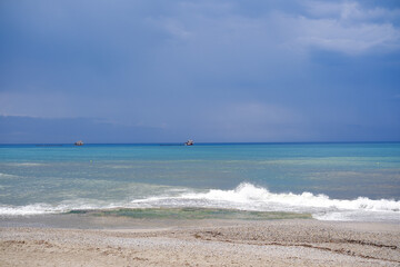 Beautiful beach and Mediterranean Sea with dark blue sky clouds before storm background.