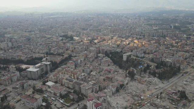 Drone over a river and cityscape of Hatay showcasing the collapsed buildings after the earthquake