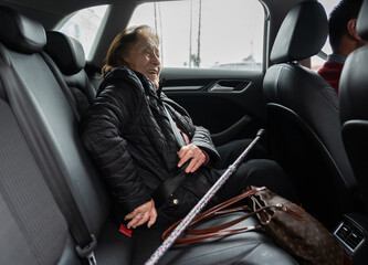 Joyful elderly woman riding in car