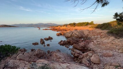 Beautiful view at dawn in a rocky beach with calm sea in the Capo Coda Cavallo of Peninsula