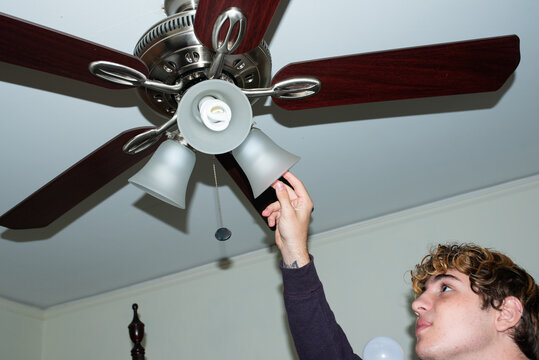 Boy changing light bulb