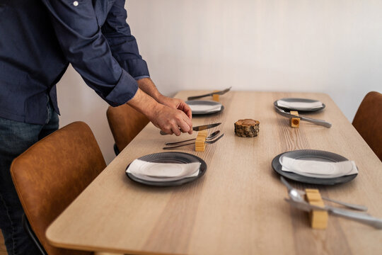 anonymous waiter setting the table in a restaurant for customers