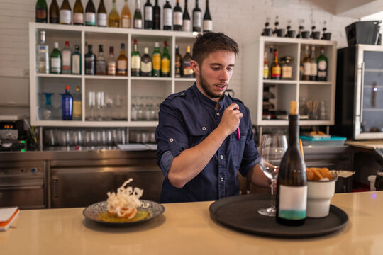 young waiter in uniform at the bar of a restaurant