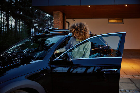 Curly woman enters the car
