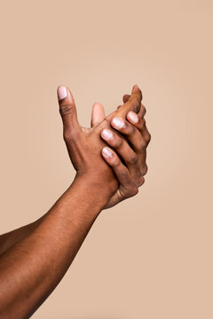 Intertwined hands on neutral background
