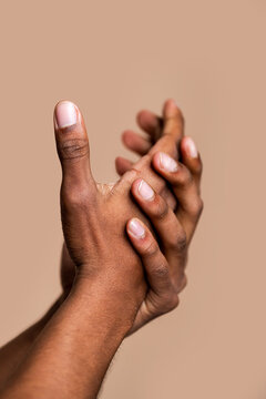 Clasped hands on neutral background