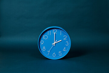 blue clock stands on a dark blue background