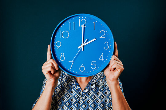 man with a clock at two oclock in front of his face
