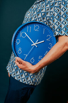man with a blue clock under his arm