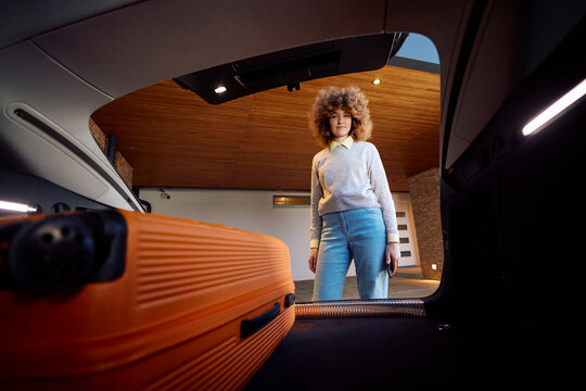Smiling woman stands in front of the open trunk