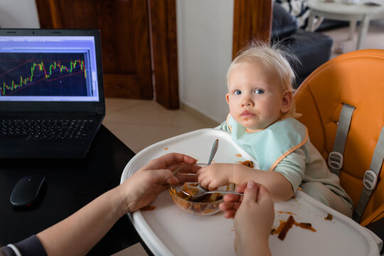 Baby girl in high chair during her mother's trading at home