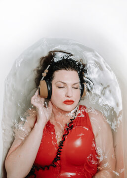 Woman in bathtub with headphones