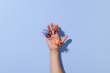 Paper cutout of dirty hand with virus on blue pastel background