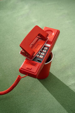 Red Push-Button Telephone on Green Background